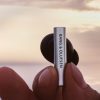 Bang & Olufsen Beo Grace Wireless ANC Earbuds in hand at sunset