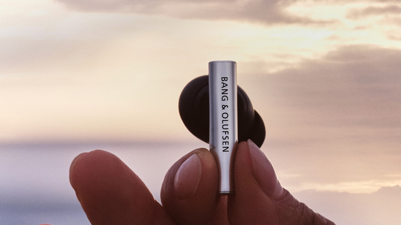 Bang & Olufsen Beo Grace Wireless ANC Earbuds in hand at sunset