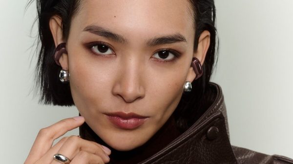 Woman wearing 2026 Bose Ultra Open Earbuds 2nd Gen in cherry chocolate color