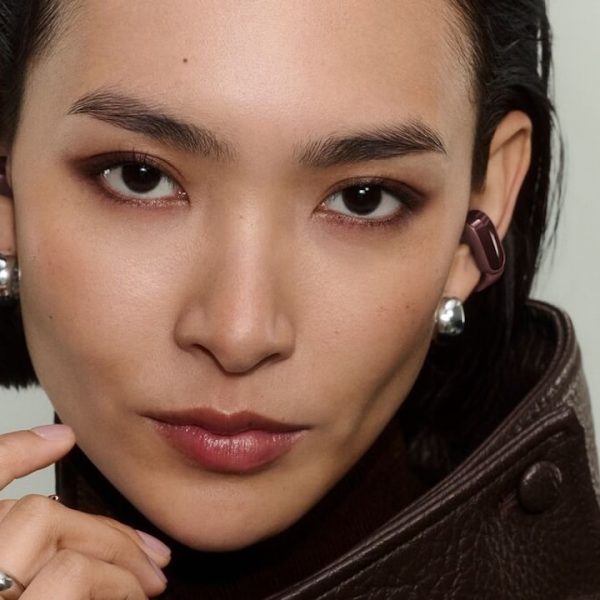 Woman wearing 2026 Bose Ultra Open Earbuds 2nd Gen in cherry chocolate color