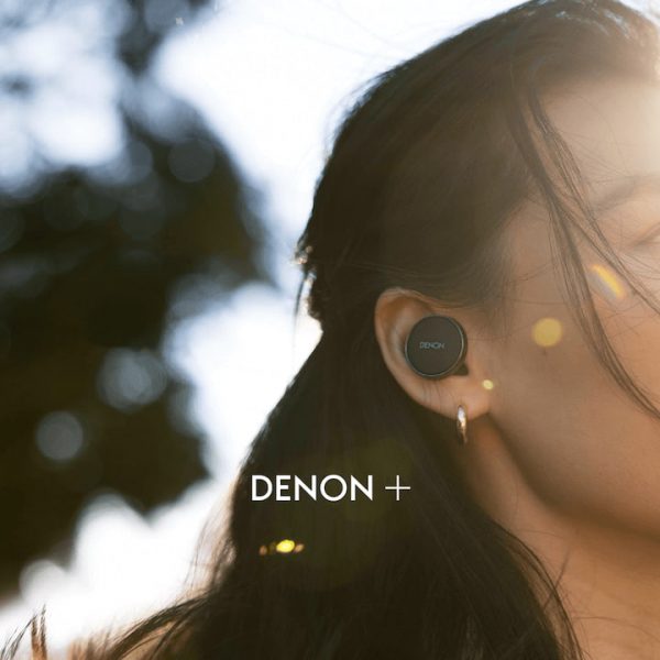 Woman wearing black Denon+ PERL wireless earbud for new subscription program