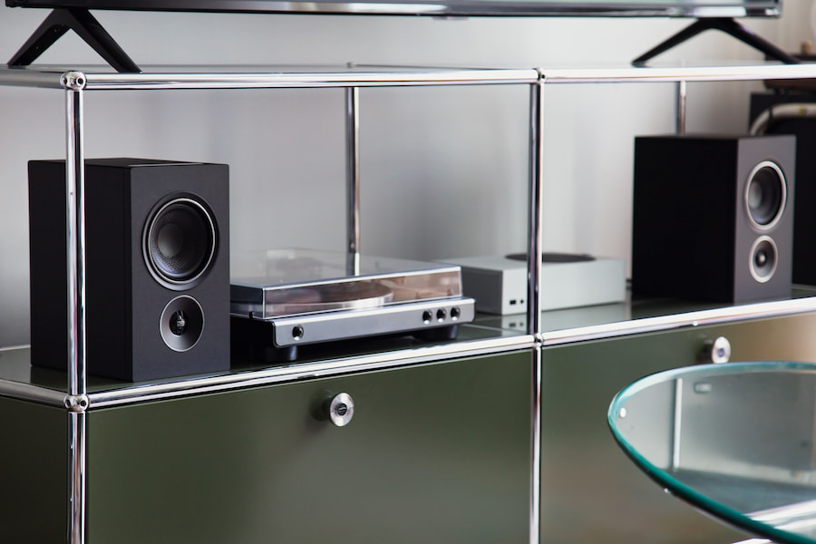 psb-iq1-speakers-on-stands-black-lifestyle-on-credenza