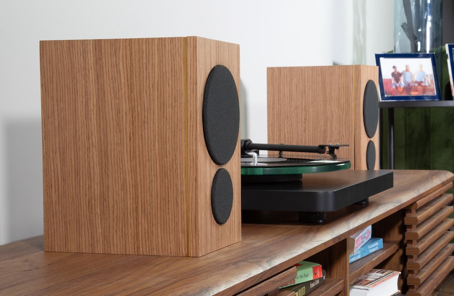 psb-iq2-walnut-with-grille-lifestyle-pair-angle